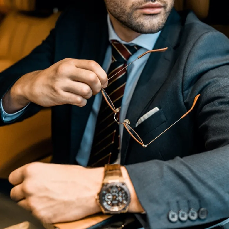 Man with luxury watch in super car